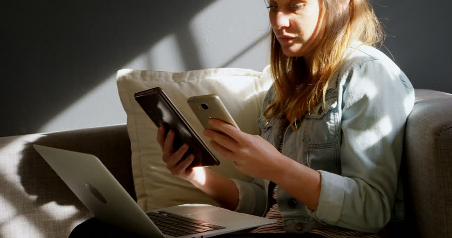 Female Caucasian jewelry designer using mobile phone and digital tablet 4k