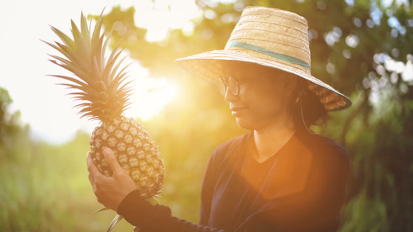 Young smart farmer show banana and pineapple.
