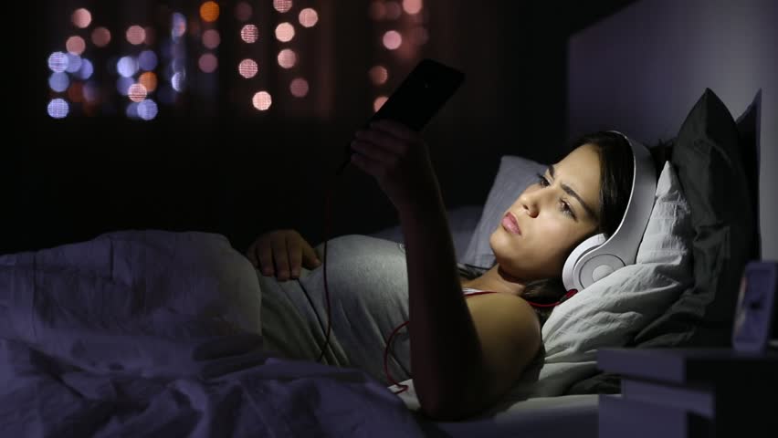 Sad girl listening to music on the bed in the night at home Royalty-Free Stock Footage #1018090852