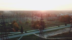 view of the structure of high-voltage lines outside the city at sunset. Camera motion back. Aerial view