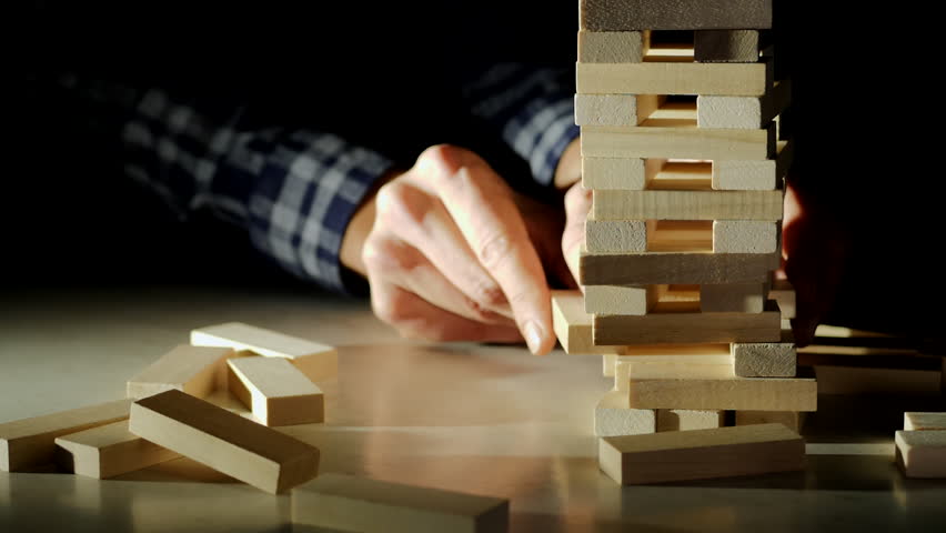Business risks in the business. Jenga falls on the table, the tower falls. Slow motion video. Male hand pulls out a wooden brick and construction collapses Royalty-Free Stock Footage #1018100848