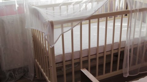 an empty crib for infants,in the room there is a new crib for babies, waiting for a baby, buying a new crib