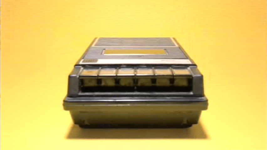 Analog VHS tape distortion: inserting and removing an audio cassette from a retro vintage player. Medium shot, yellow background.
 Royalty-Free Stock Footage #1018105288