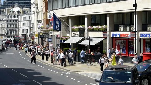 London, UK - June 22, 2018: High angle, aerial view from moving, driving car on street road with center of downtown city, many people walking on Ludgate Hill, shops stores, Sports Direct