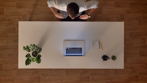 Top down shot time lapse male in wooden office using laptop while sitting at the working desk , day start and finish Video de stock