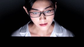 Woman working late at her home office. Close up of beautiful asian woman talking to customer using video call in computer, wearing glasses, upset mood. Modern global connected business concept.