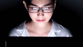 Woman working late at her home office. Close up of beautiful asian woman talking to customer using video call in computer, wearing glasses, happy mood. Modern global connected business concept.