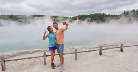 New Zealand tourist attraction couple tourists taking selfie travel destination, Waiotapu. Active geothermal famous attraction Champagne pool, Okataina Volcanic Centre, Reporoa, in Taupo Volcanic Zone