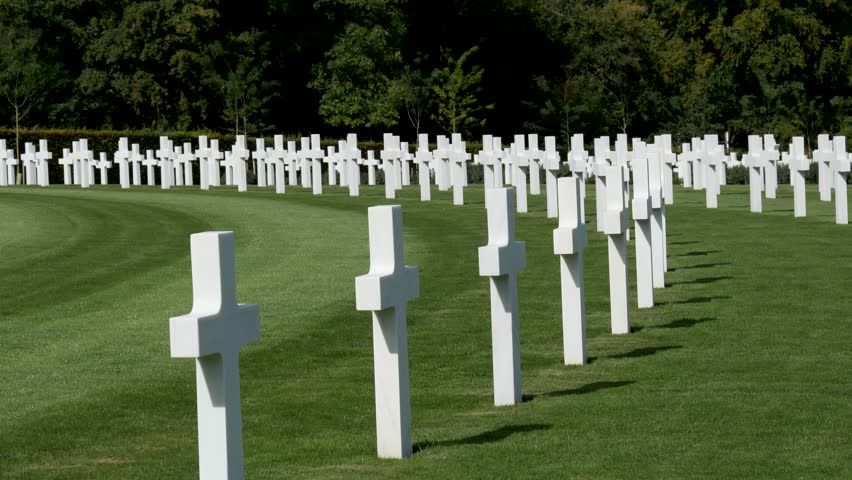 Pan-Curving rows of white crosses mark the graves of American dead at the WWII American Cemetery near Cambridge