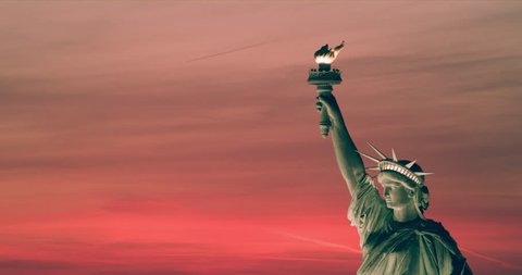 Aerial view of the Statue of Liberty at sunset, New York City, bright summer light. Medium to wide shot on 4k RED camera on helicopter. 