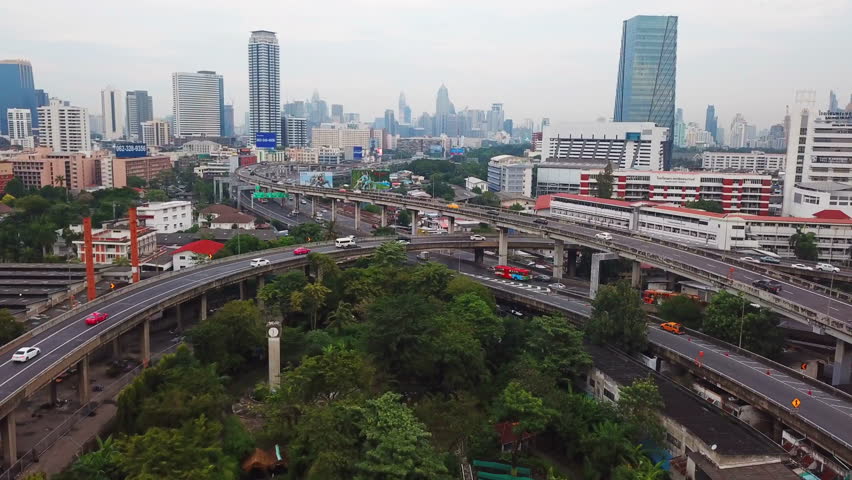 Cars driving on bridge roads shaped curve highways with skyscraper buildings. Aerial view of Expressway Bangna, Klong Toey in structure of architecture concept, Urban city, Bangkok, Thailand. Royalty-Free Stock Footage #1018137079