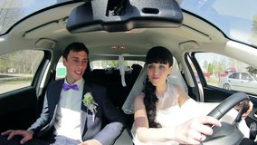 The bride and groom  have fun behind the wheel of car. Wedding. video HD