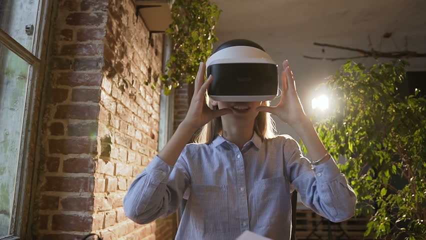 Beautiful young woman using 3D virtual reality headset. Virtual reality game. Student girl with pleasure uses head-mounted display. Future is right now. Slow motion | Shutterstock HD Video #1018146859