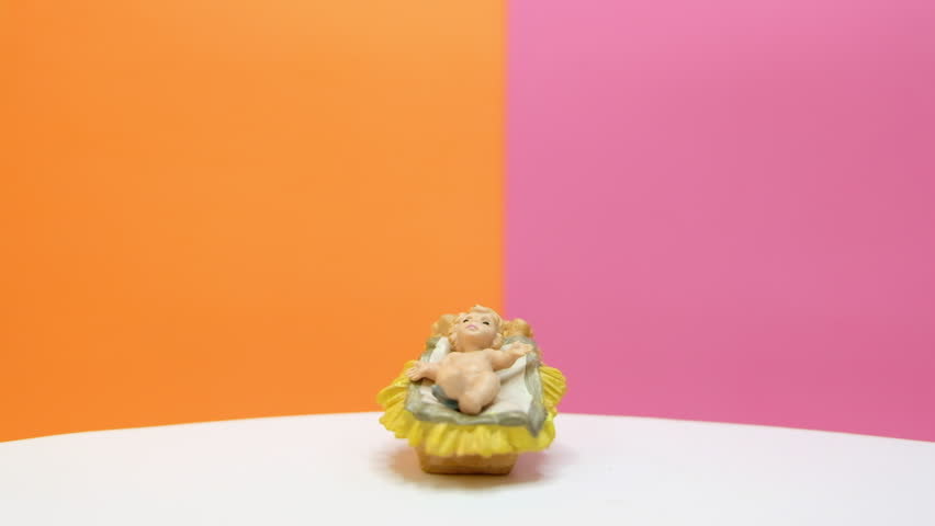 Jesus Christ in the manger rotating with colourful background. Footage ready for loop.
