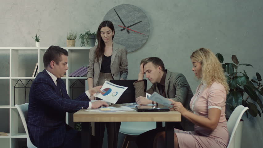 Anxious female team leader scolding her colleagues for bad results and lack of enthusiasm during meeting in boardroom. Tired overworked manager falling asleep during business team meeting at office. Royalty-Free Stock Footage #1018149544