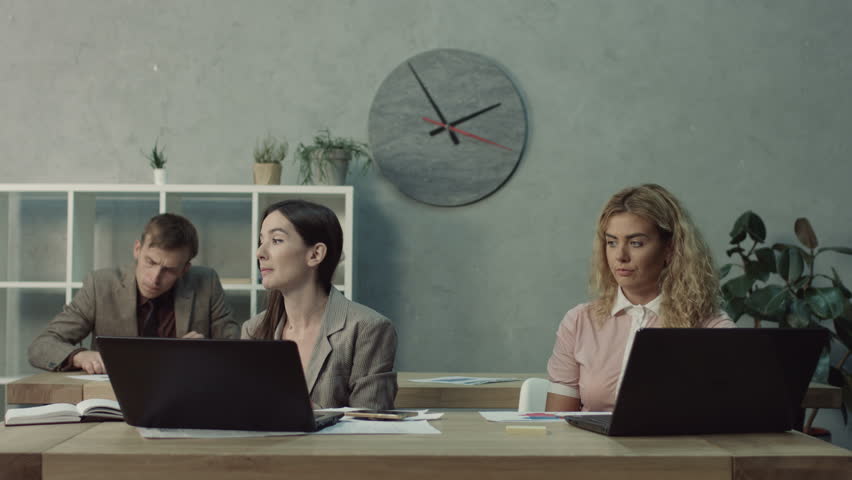 Indecent female office woman stealing completed colleague work and passing off to the boss as her own while working in modern office. Cheating worker stealing ready report from unaware coworker. Royalty-Free Stock Footage #1018149574