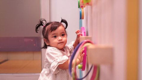 Cute toddler girl playing in the Nursery Room at the shopping mall.Interactive play room at nursery.
