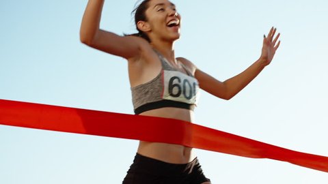 Female athlete on track. Young asian runner runing on track of stadium, happily crossing the red finish line, getting ready for competition