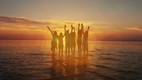 A group of five young teenager friends travel to the beach looking at the sea. Beauty and joyful teenager friends having fun over summer sunset. Beach party. Sun flare. Slow motion 库存视频