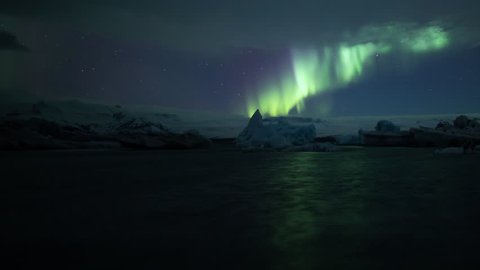 Aurora borealis over blue glacial icebergs, reflecting in water, Jokulsarlon Iceland.mov
