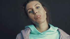 Outdoor lifestyle portrait of beautiful young woman blowing a bubble gum balloon. Urban city lifestyle. Slow motion video