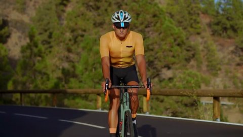 a man in a yellow t-shirt riding a Bicycle on a mountain serpentine