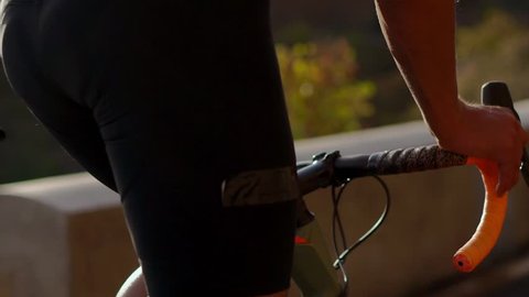 Close-up of a cyclist riding on a mountain road in the summer. Wheels, steering wheel and pedals