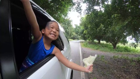 Happy Girl Playing with cloth on Window Car, Family Traveling on Countryside concept