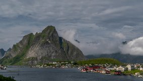 Timelaspe Moving clouds over traditional Norwegian fisherman's cabins, rorbuer, on the island of Hamnoy, Reine, Lofoten islands, Norway. Panorama 4K