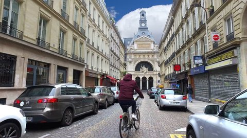 Paris, France - May 11, 2017: Bicycle passing by on street in front of BNP Paribas building on Rue Bergere in Paris. BNP Paribas is a French bank and financial services company with headquarters in Pa