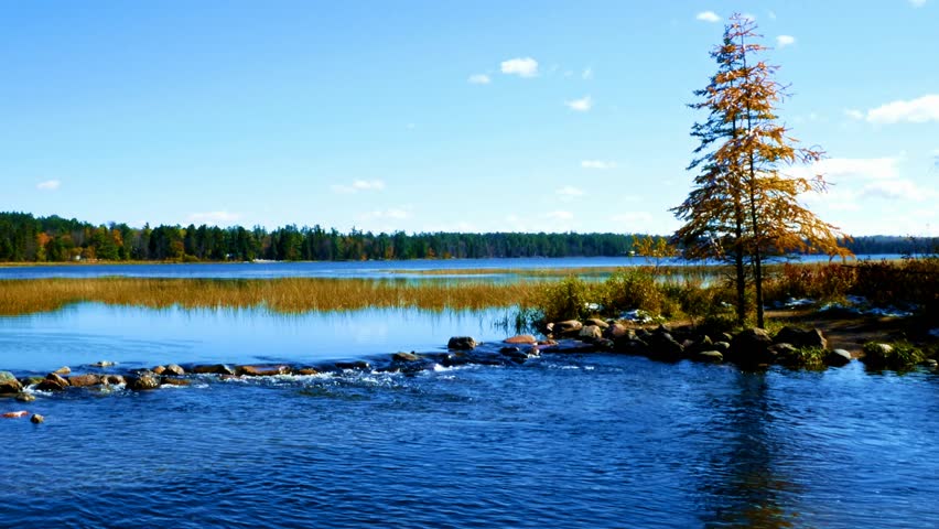 Lake Itasca held behind a man made dam at the headwaters of the Mississippi River at Lake Itasca State Park in Minnesota. Tourists walk on the rocks to say they have walked across the river.