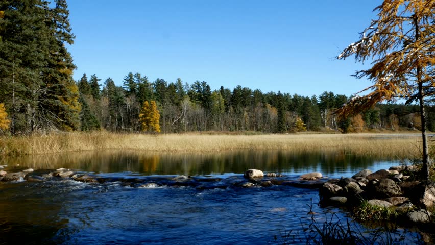 Lake Itasca held behind a man made dam at the headwaters of the Mississippi River at Lake Itasca State Park in Minnesota. Tourists walk on the rocks to say they have walked across the river.
