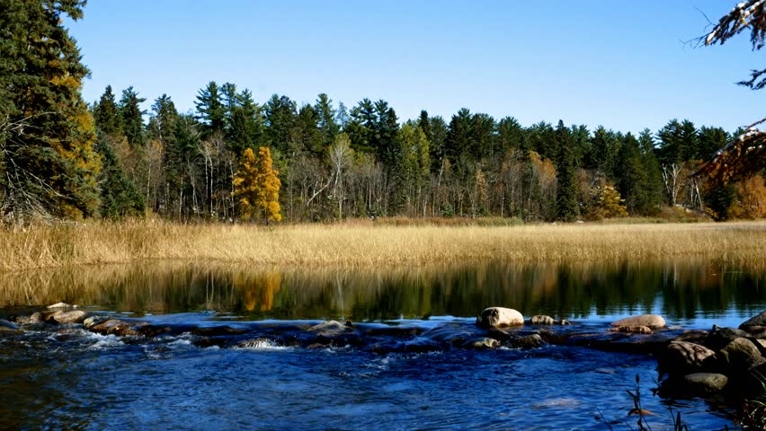 Lake Itasca held behind a man made dam at the headwaters of the Mississippi River at Lake Itasca State Park in Minnesota. Tourists often walk on the rocks to say they have walked across the river.