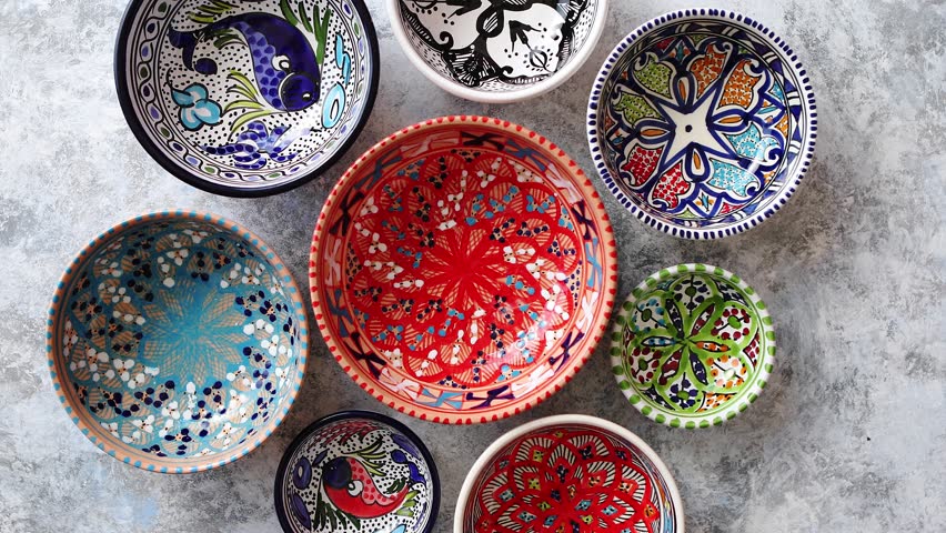 Collection of empty moroccan colorful decorative ceramic bowls. Composition captured from top view, flat lay. Placed on grey stone background. | Shutterstock HD Video #1018207951