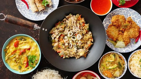 Asian oriental food composition in colorful dishware, served on dark rustic background, top view. Chinese, vietnamese, thai cuisine set. With copy space.
