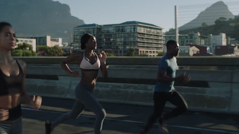 multi ethnic group athletes running friends enjoying competition race jogging exercising together focused on healthy fitness lifestyle in urban city at sunrise
