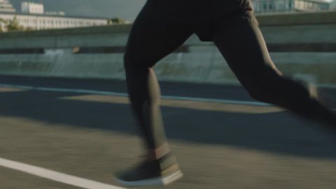 close up athlete legs running on road fit runner jogging sprinting endurance exercise in urban city morning at sunrise