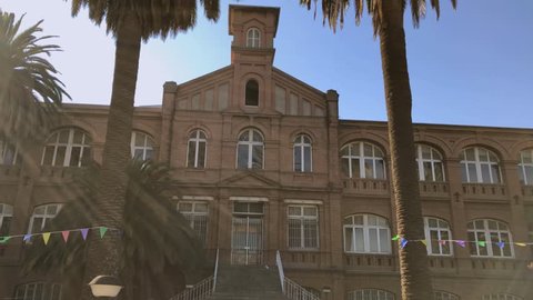 Facade of the old Asylum of the Little Sisters of the Poor located in Santiago de Chile. Convent of Nuns built in 1898. 2 palms