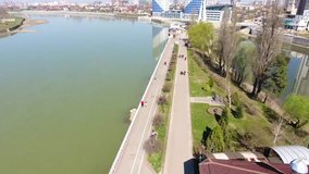 Flying over river and buildings at day. 4k footage. Aerial cityscape flythrough video of Krasnodar and River Kuban with a view of skyscrapers in Park. Aerial view of landscape City.