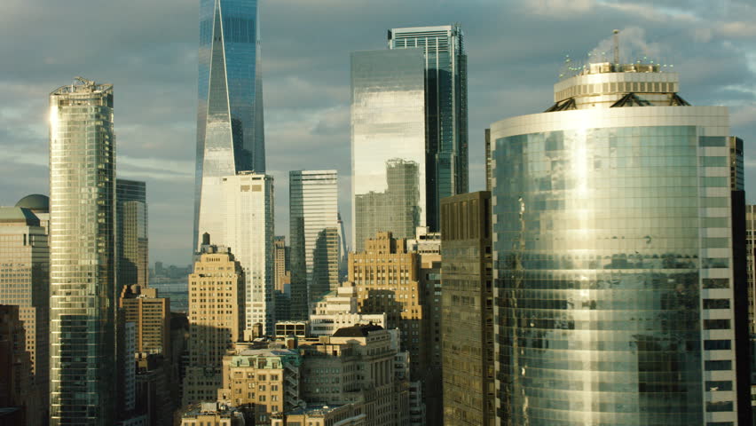 Aerial view of tall buildings and skyscrapers in downtown, Manhattan, New York City, bright day lighting. Wide shot. 4k shot with a RED camera.