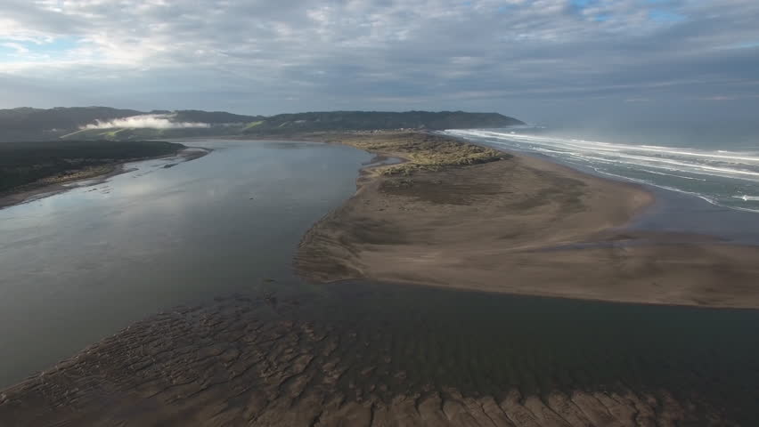 Aerial view of Waikato river mouth and surf waves at Port Waikato, New Zealand