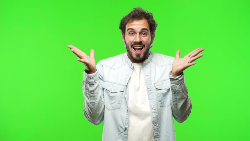 Young man on green chroma very happy and excited, raising arms, celebrating a victory or success, winning the lottery