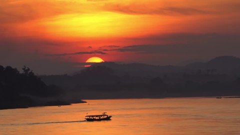 Amazing Silhouette sunset Landscape of the Mekong River with cruise passing at Chiang Khan, Loei province unseen Thailand.