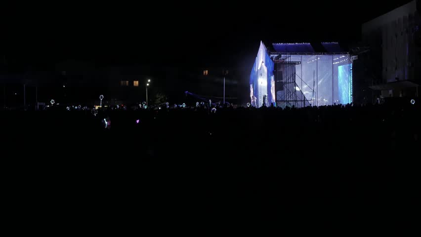 Crowd people at music concert . Cheering crowd in front of bright colorful lifestyle stage lights . silhouettes of concert crowd in front of bright stage lights. crowd of people at a concert concept