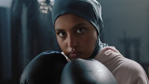 portrait muslim woman kickboxer ready for training fighter looking confident at camera tough female kickboxer wearing hijab headscarf in fitness gym close up