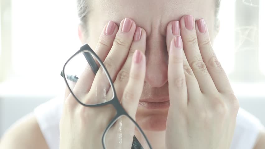 Feeling tired and stressed. Frustrated young woman keeping eyes closed and massaging nose while sitting at her working place in office. Young Businesswoman is tired and feels stressed out.   | Shutterstock HD Video #1018251811