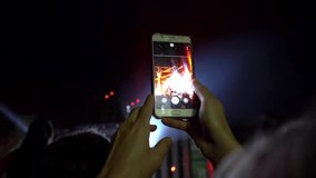Fans are filming a concert on a smartphone. Live broadcast of the concert in social networks. People make photos and videos at the festival. World tour of popular musicians