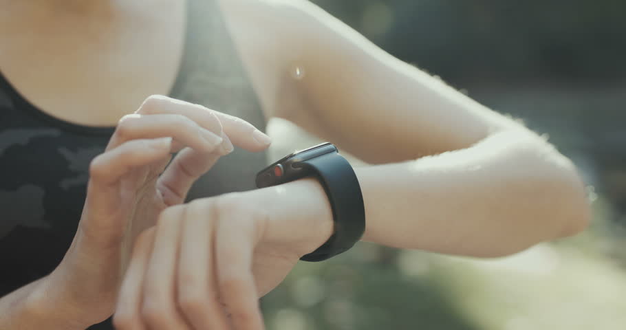 Young woman trying new smart watch. Smart watch. Woman Using Smart Watch and Smart Phone. Closeup
