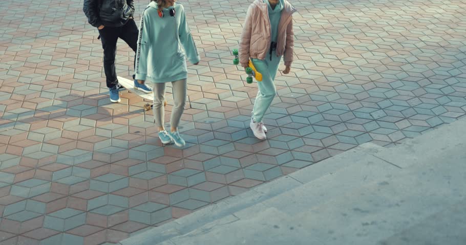 Two girls run up the stairs. Young women have fun outside the city.