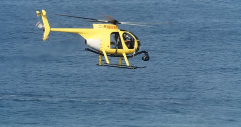 Cinema helicopter filming large surf in Hawaii during Pacific storm